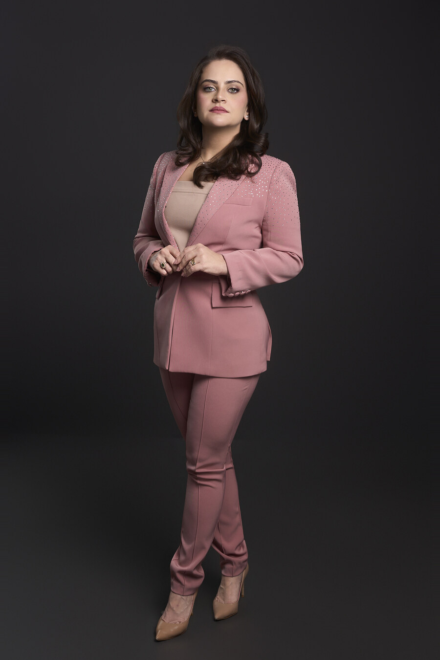 Dra. Claryssa Nascimento em traje rosa, retrato de estúdio de corpo inteiro