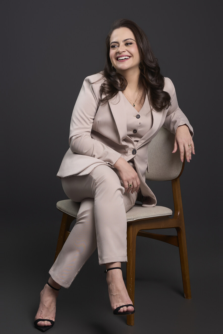 Dra. Claryssa Nascimento sentada, sorrindo, retrato de estúdio